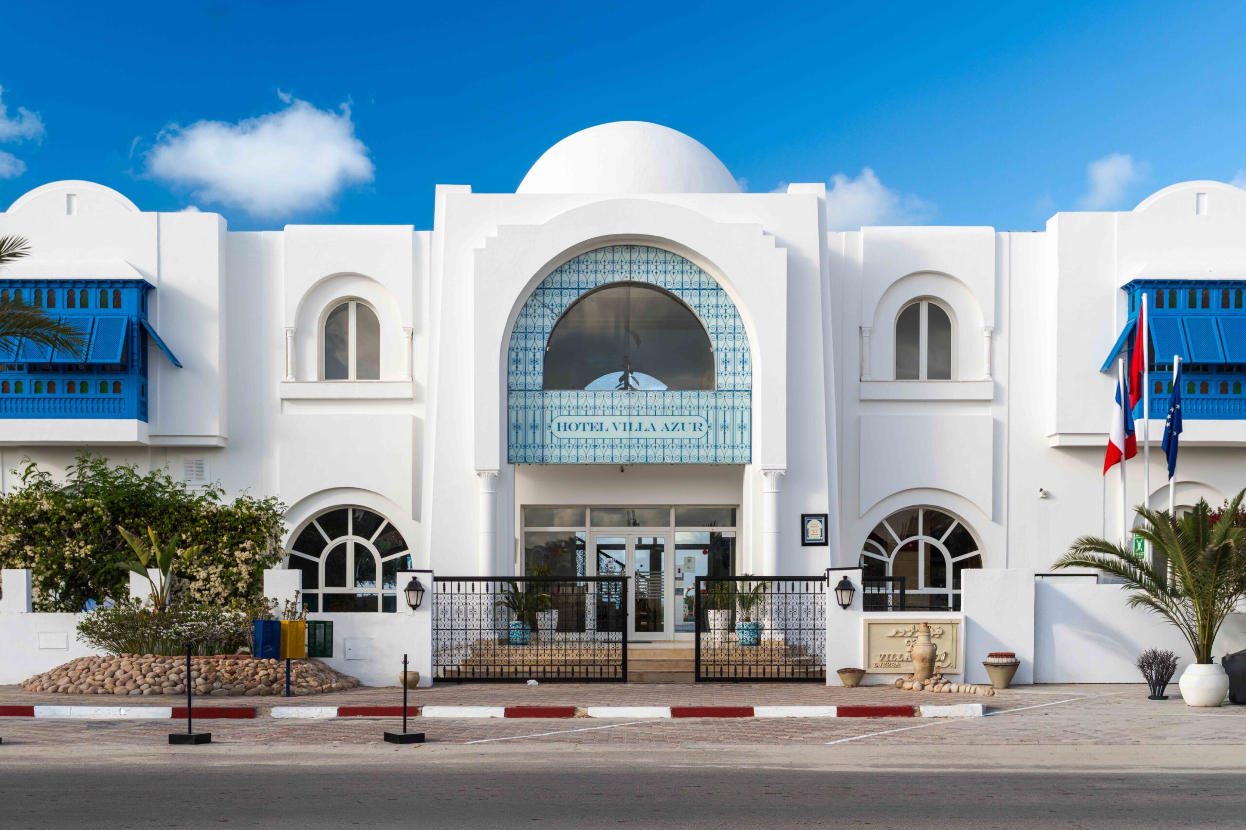 Façade blanche de l'Hôtel Villa Azur avec dôme et fenêtres bleues mauresques
