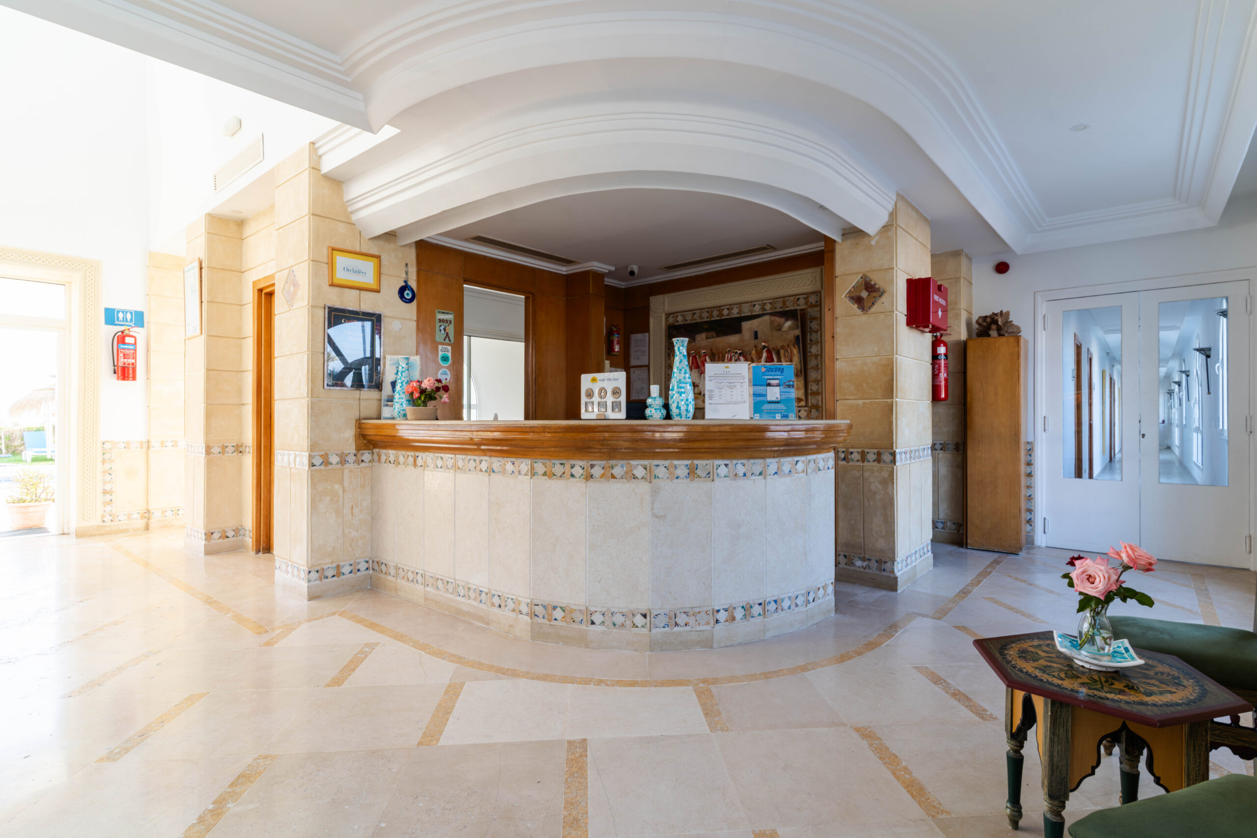 Réception de l'hôtel avec comptoir en bois incurvé et sol en marbre