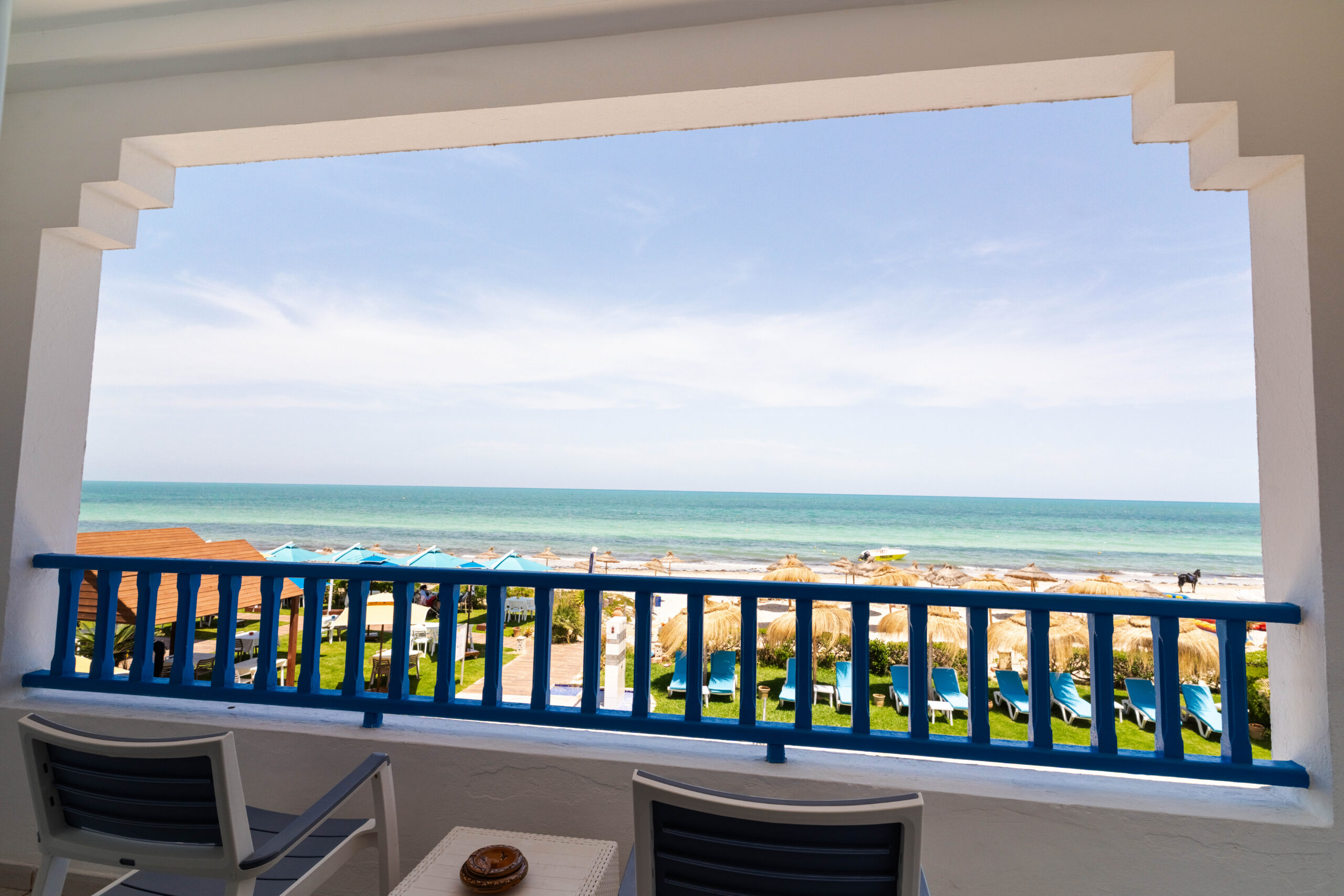 Vue depuis un balcon sur la plage et ses parasols traditionnels
